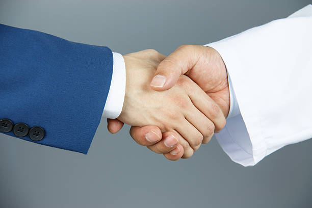 istock Doctor and businessman shaking hands 475762856