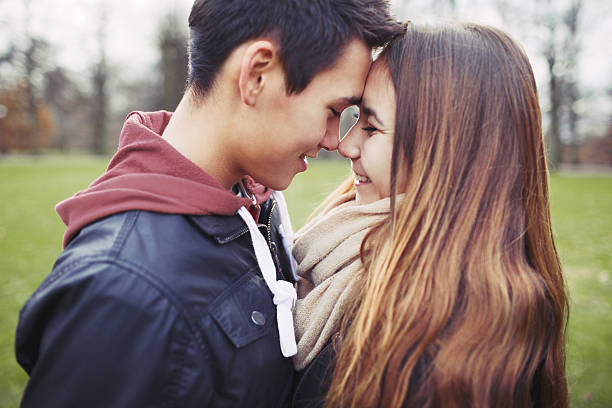 Romantic young couple sharing a special moment outdoors Close up of cute teenage couple in love sharing a special moment. Romantic young man and woman outdoors in park. teen romance stock pictures, royalty-free photos & images
