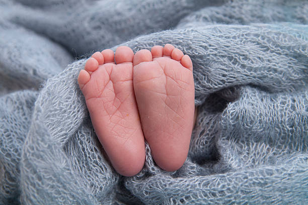 istock tiny foot of newborn baby 475766204