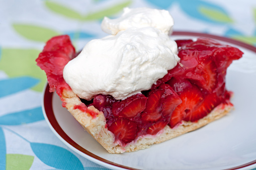 A slice of strawberry pie with whipped cream is a perfect summer dessert!