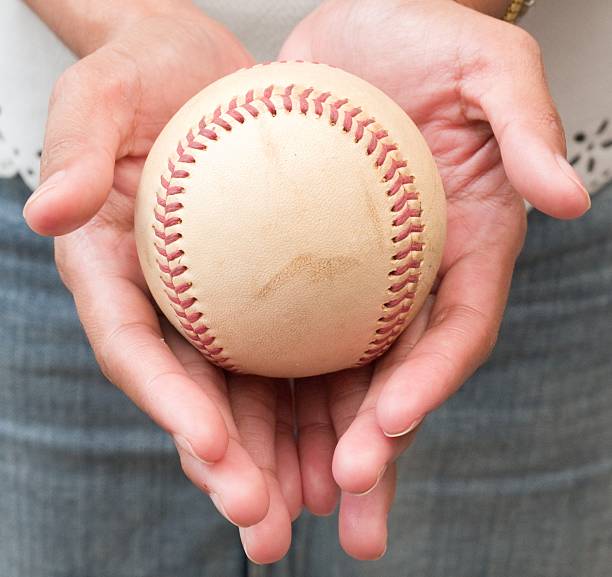 istock Girl Holding Baseball in Two Hand 475766976
