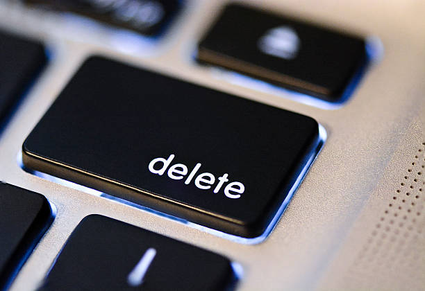 Delete Key A close up of a black key on a computer. The key says "delete" in white writing. The key is lit up from behind.  The other keys around the delete key are blurry.  delete key stock pictures, royalty-free photos & images