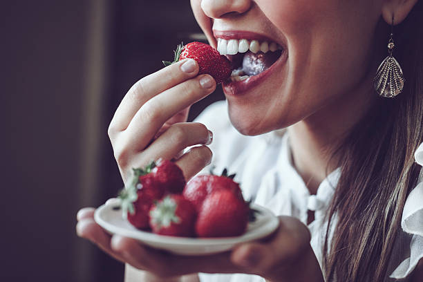 deliciosos morangos - women eating fruit food - fotografias e filmes do acervo