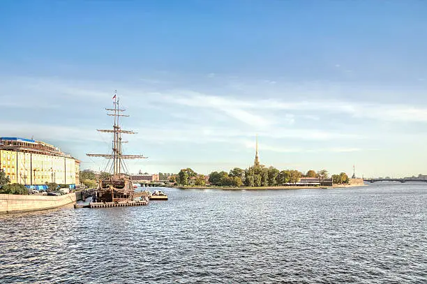 View of the reconstructed sea sailboat standing near the shore and the Peter and Paul Fortress