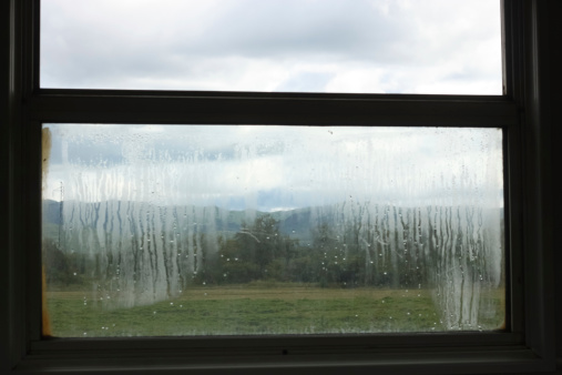 The commune of Larochette in Luxembourg viewed through glass window panes covered with rain drops.