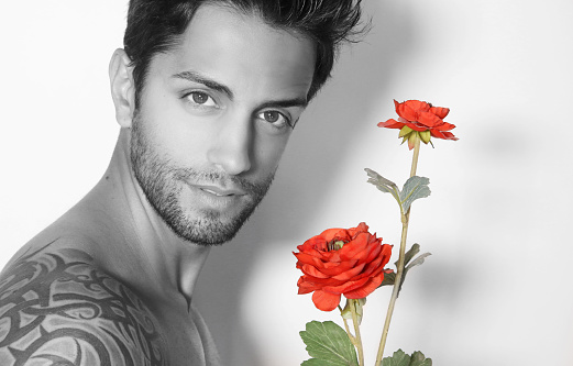 Latin handsome man holding a rose in his hand
