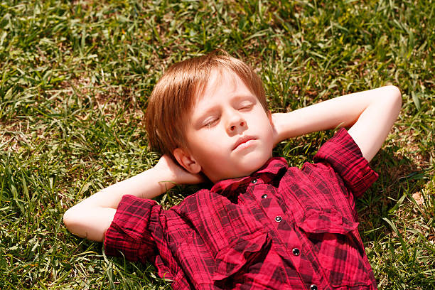 istock Top view of sleeping little boy on grass 475776366
