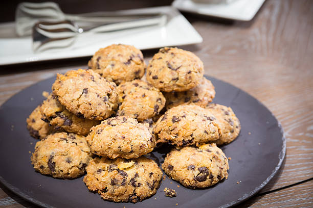 biscuits avec raisins sur table en bois - chocolate chip cookie cookie chocolate stack photos et images de collection