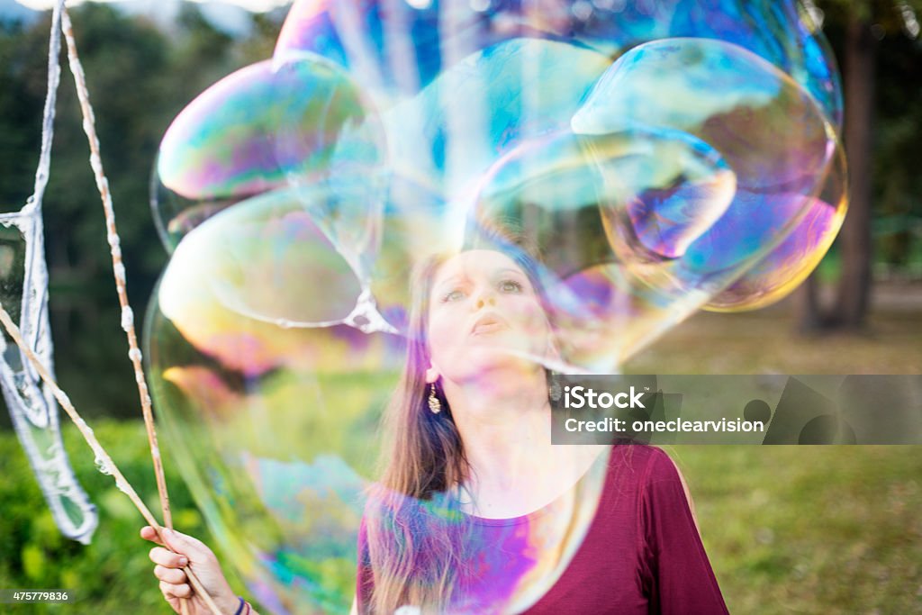 Giant Soap Bubbles Woman making giant soap bubbles in a park. Bubble Wand Stock Photo