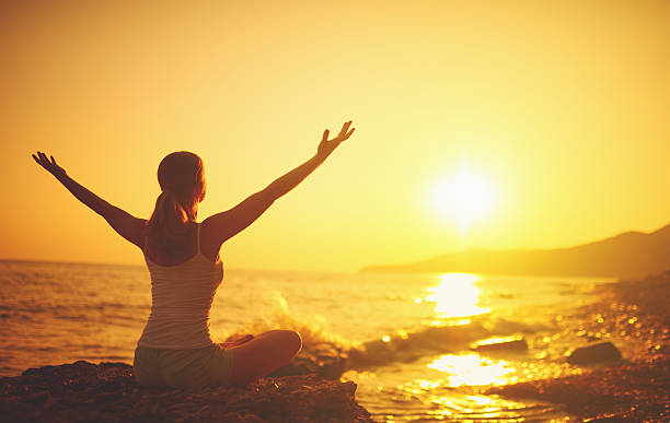 yoga al atardecer en la playa. mujer haciendo yoga - beach sea zen like nature fotografías e imágenes de stock