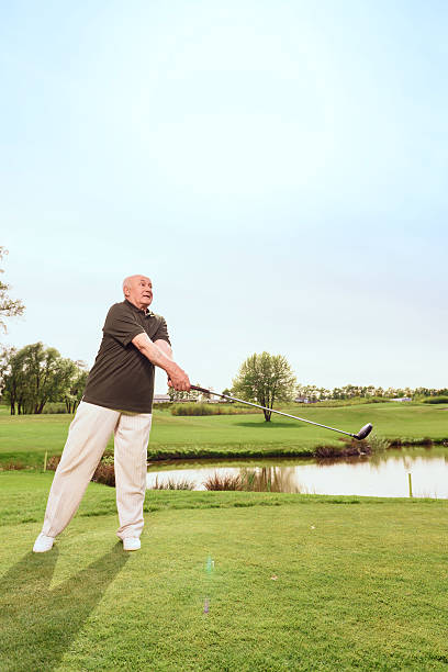 istock Senior man driving ball towards on course 475781896