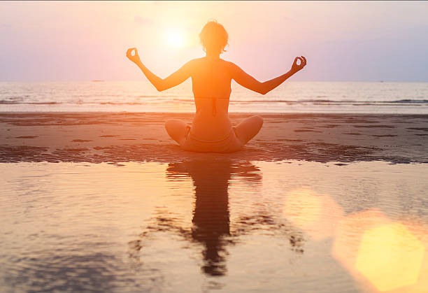 istock Silhouette young woman practicing yoga on Ocean beach 475785234