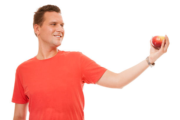 istock happy man in red shirt with apple isolated 475786047