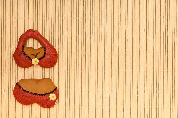 istock Red bikini underwear shape gingerbread cake cookie on bamboo mat 475786227