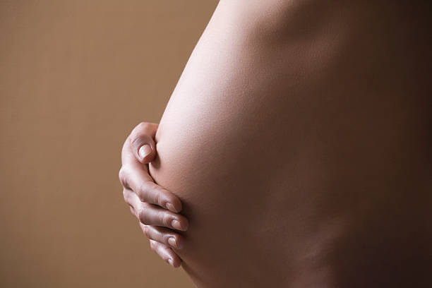 istock Pregnant Woman Touching Tummy 475787471