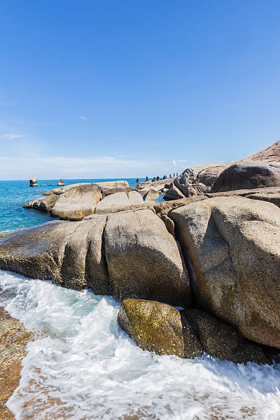 istock rocks on the beach with wide angle of wild beach 475788927