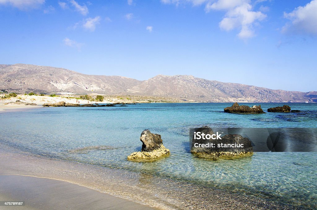 Elafonissi beach, with pinkish white sand and turquoise water, Crete Elafonisi or Elafonissi, "deer island" in Greek, is an island located close to the southwestern corner of the Mediterranean island of Crete, Greece. Elafonisi is an oblong, which often "breaks" in two parts by water giving the impression of being a separate island. The island is a protected nature reserve. Beach Stock Photo