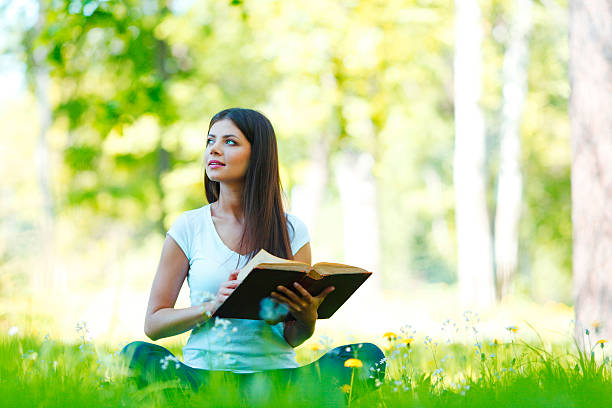 istock Woman reading book outdoors 475789803