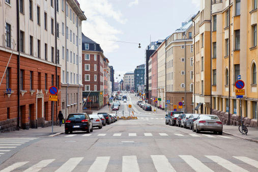 Street, machines and facades of houses in city Helsinki