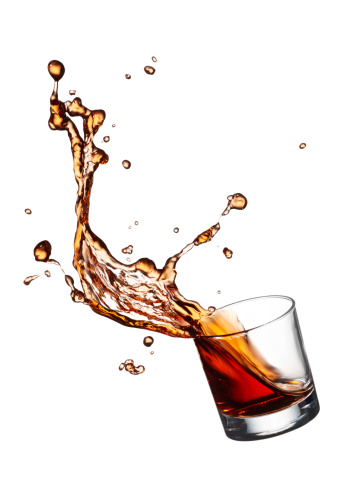 glass of splashing whisky isolated on white