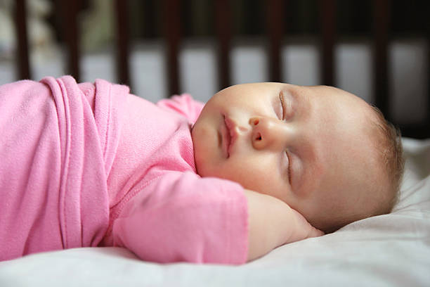 Sweet Newborn Baby Girl Asleep in Crib stock photo