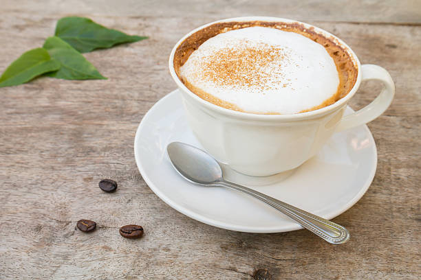 istock Coffee cup and beans on wooden table 475794041