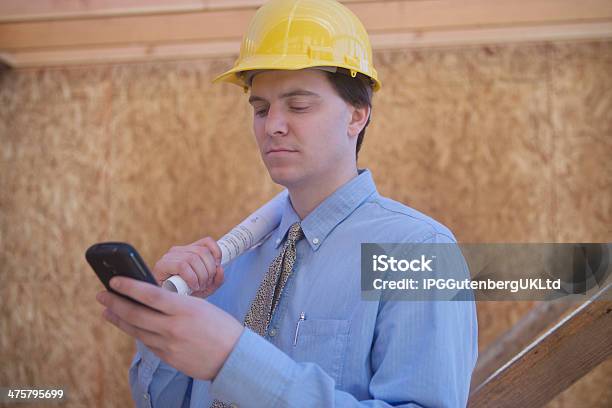 Arquitecto Usando Teléfono Celular Con Blueprint En El Hotel Foto de stock y más banco de imágenes de Accesorio de cabeza