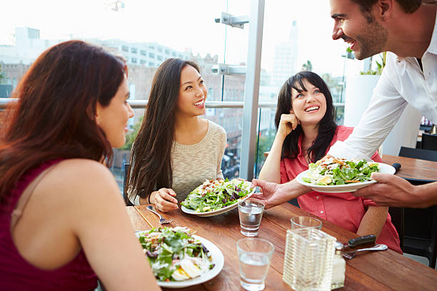 istock Three Female Friends Enjoying Lunch At Rooftop Restaurant 475802563