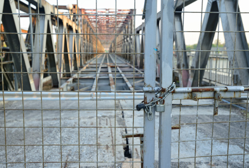 An old rusty iron bridge locked down to public access