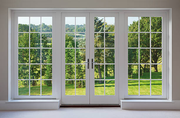 beautiful garden windows a set of finely crafted wooden Georgian style windows with doors set in a white frame, with white sills and caramel coloured walls. The view through the windows are towards a beautiful  countryside garden. georgian style photos stock pictures, royalty-free photos & images