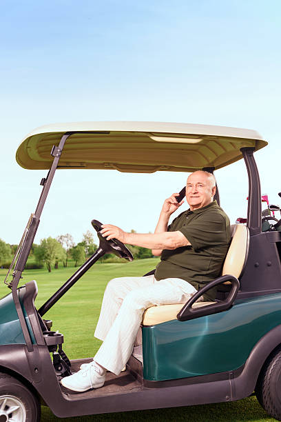 istock Senior man using mobile phone and driving cart 475809052