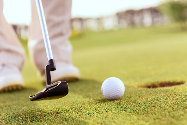 istock Close up of man putting ball into hole 475809058