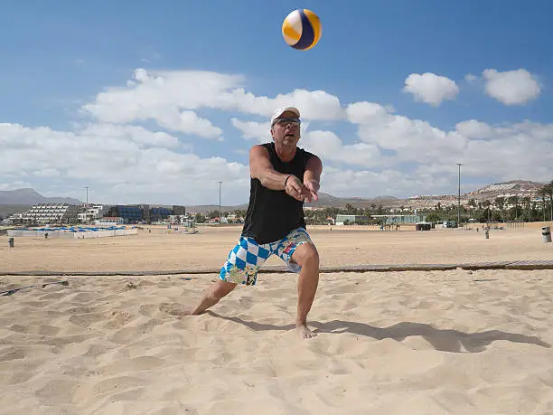 Beach volleyball man playing forearm pass hitting volley ball