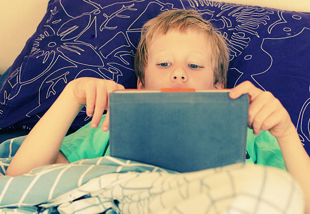 istock seven year old boy lies in bed 475815328