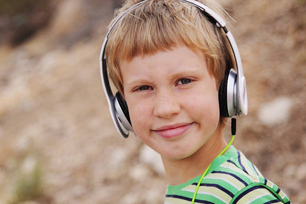 süße autistic boy mit kopfhörer - urban growth audio stock-fotos und bilder