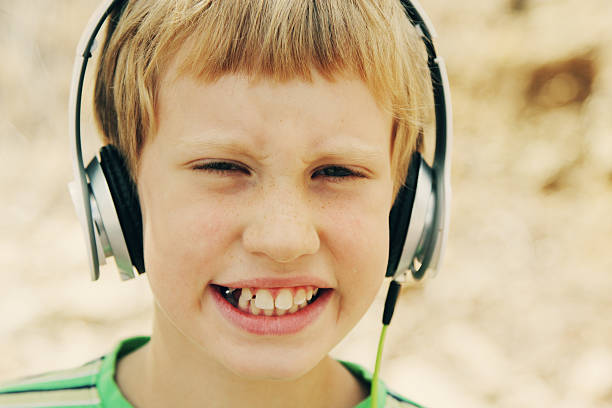 süße autistic boy mit kopfhörer - urban growth audio stock-fotos und bilder