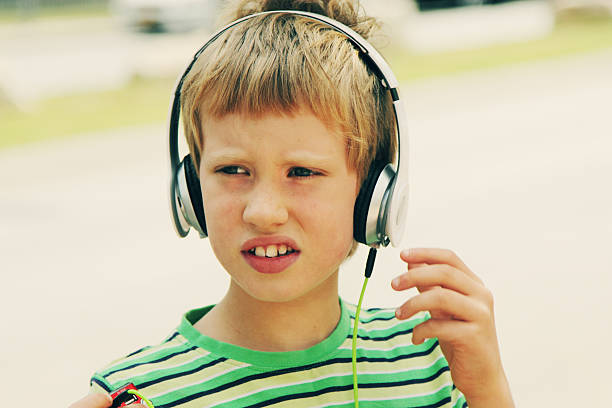 süße autistic boy mit kopfhörer - urban growth audio stock-fotos und bilder
