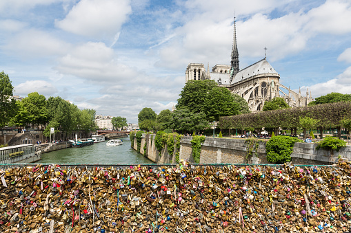 Paris, France - May 28, 2015: Love padlocks representing eternal love of couples who lock padlocks at the bridge Pont de L'Archeveche over the Seine river