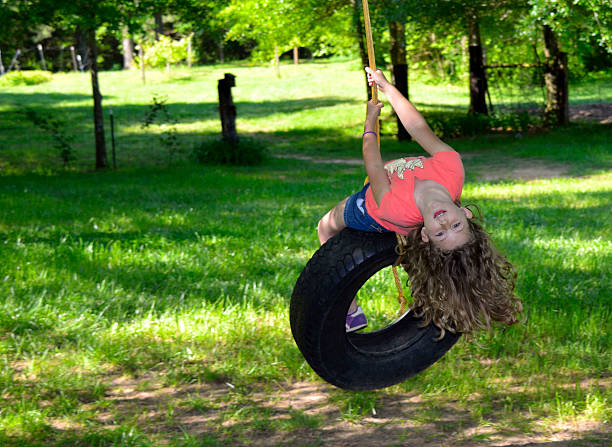 giovane ragazza su un altalena con pneumatico - freedom tire swing tire swing foto e immagini stock