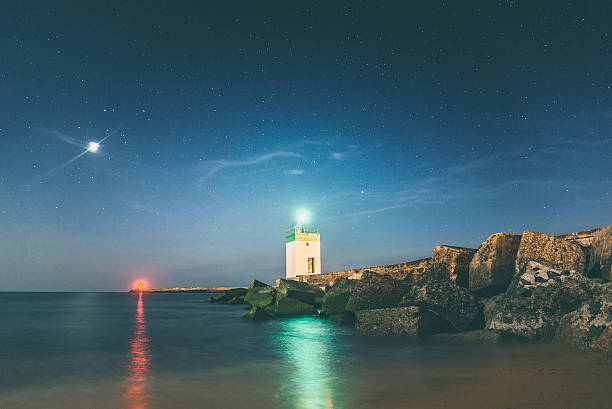 Lighthouse at night A lighthouse and a starry night. lighthouse lighting equipment reflection rock stock pictures, royalty-free photos & images