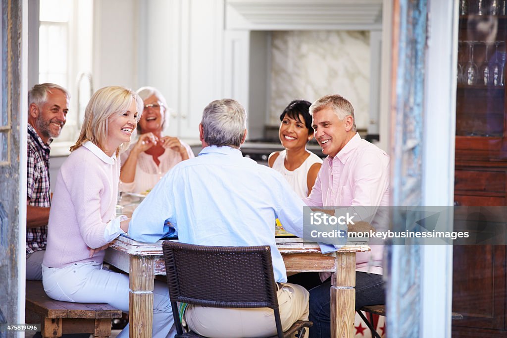 Group Of Mature Friends Enjoying Meal At Home Together Senior Adult Stock Photo