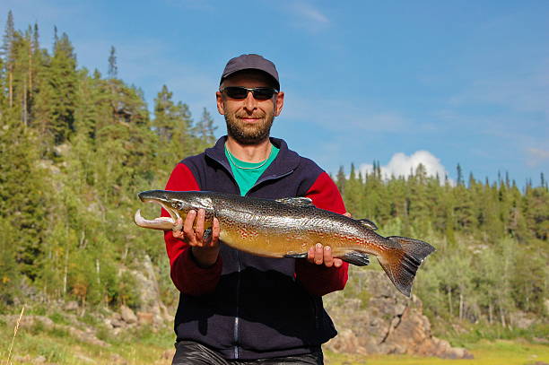 istock Fisherman caught a nice male salmon in the north river. 475823572