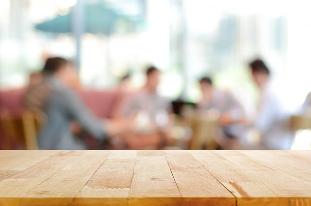 istock Wood table top with blurred people in cafe as background 475826248