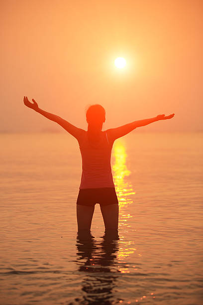 istock cheering woman seaside sunrise 475827001