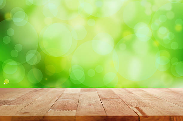 istock Wood table top on green bokeh abstract background 475827164