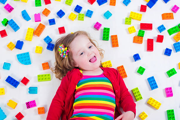 istock Sweet little girl playing with colorful blocks 475827310