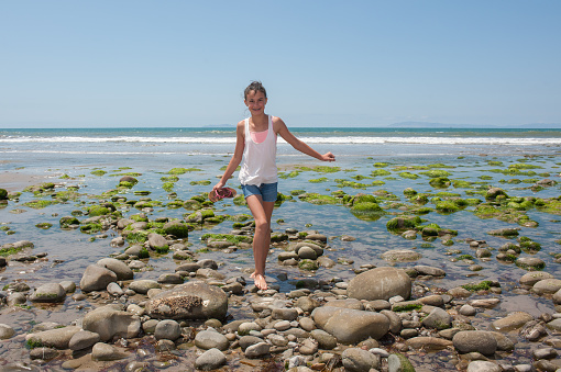 Female child navigates across the tide pools