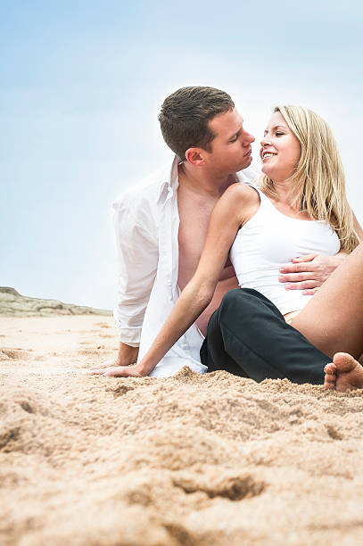 istock young attractive couple flirting on beach 475832031