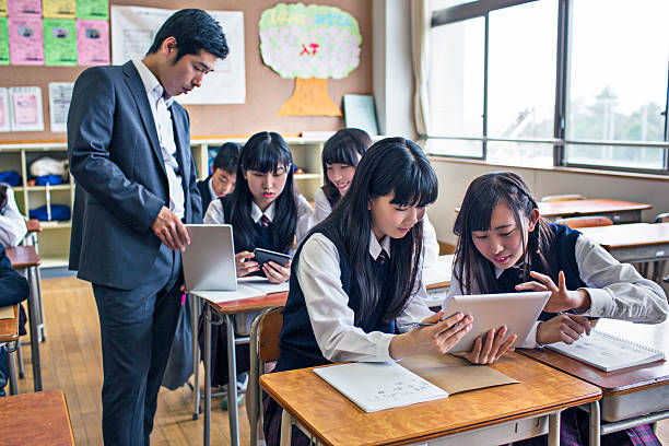 японский детей, работающих с цифровых планшетов в школе - elementary student classroom education elementary school building стоковые фото и изображения