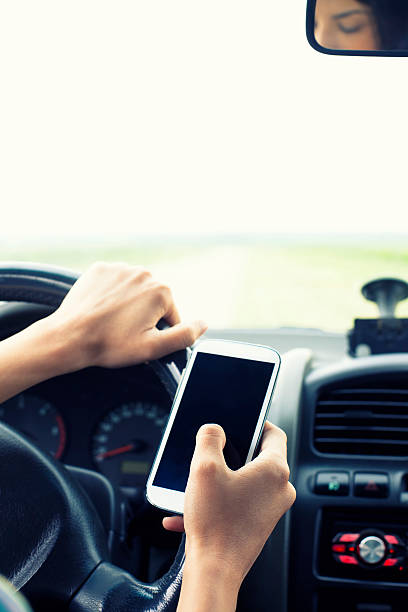 istock Woman Using Mobile Phone in Car 475832312